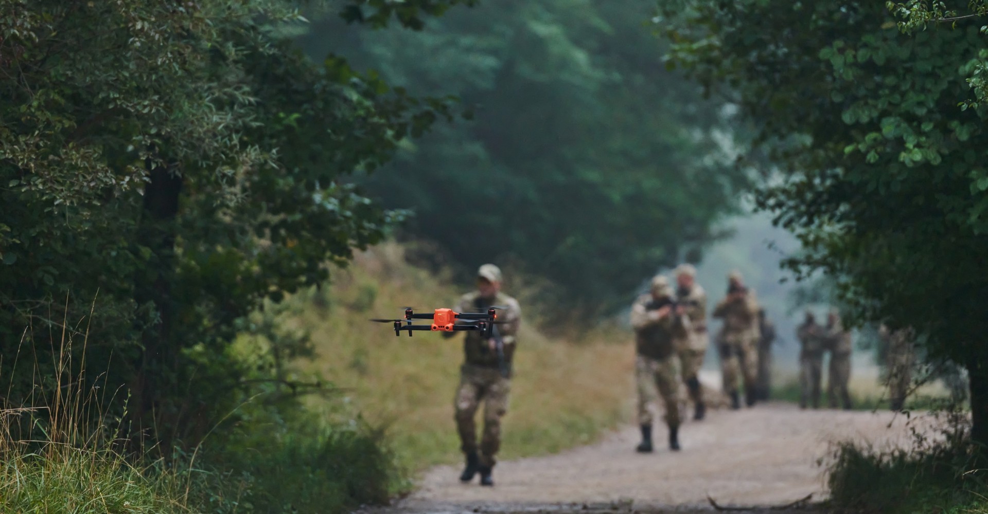 Elite military unit parading and securing the forest, utilizing drones for terrain scanning and reconnaissance, showcasing their advanced skills and specialized training in high-risk operations.